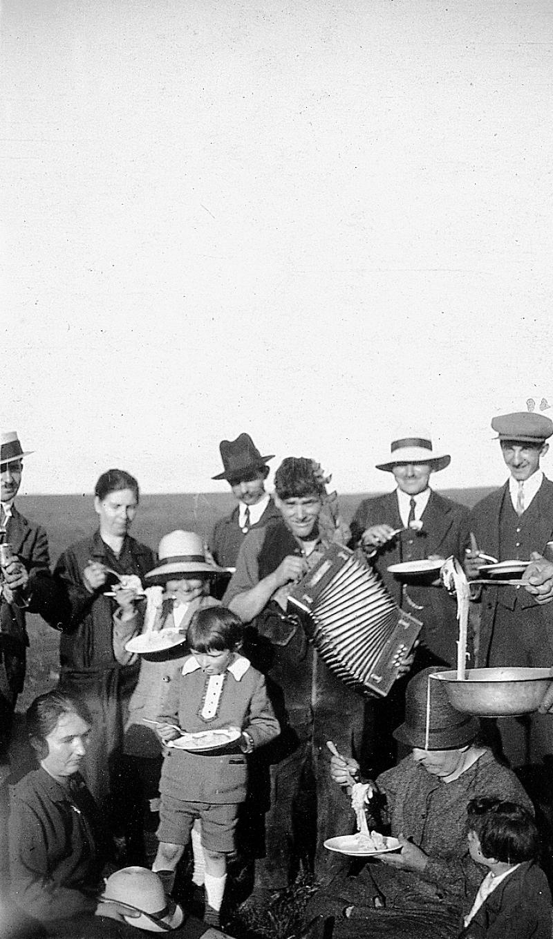 Dégustation en plein air d'un aligot (cuècha) avec accordéoniste (acordeonista), à La Branque (commune d'Alpuech), vers 1930