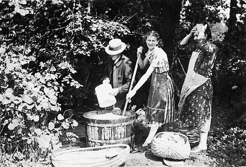 Homme et femmes faisant la lessive (bugada) dans un baquet en bois (barquet), à Soulaquet, 1936