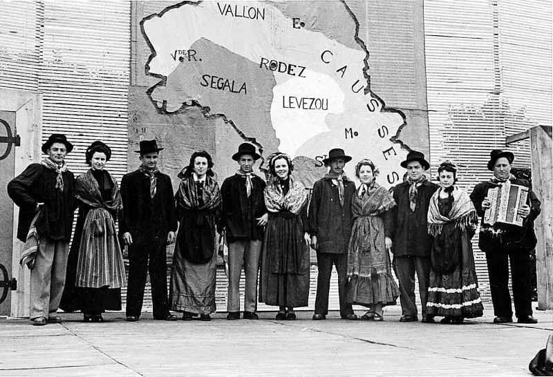 Danseurs (dançaires) et accordéoniste (acordeonista) costumés de Laguiole devant carte de l'Aveyron au congrès de la Jeunesse agricole catholique (JAC), à Rodez, 13 juin 1954