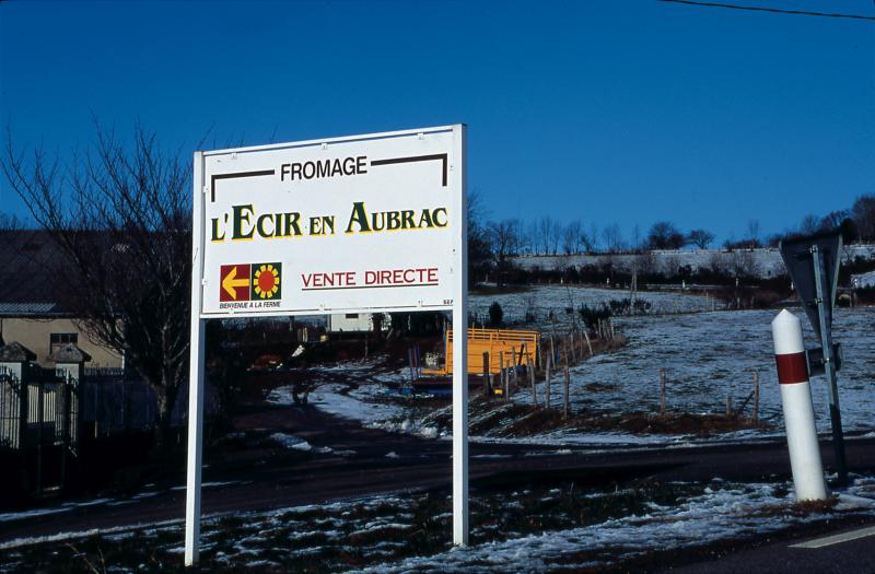 Panneau de signalisation en français et en occitan Fromage L'Ecir en Aubrac, vente directe, en Aubrac (secteur de Laguiole), janvier 2001