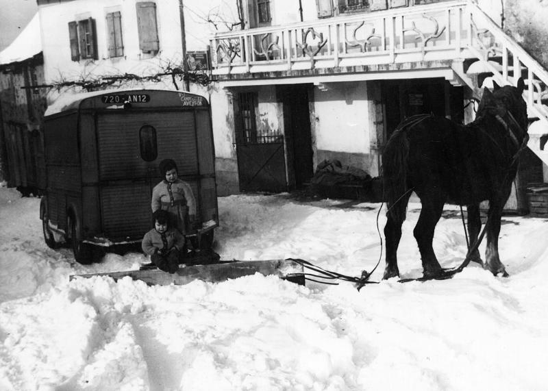 Enfants dans la neige (nèu), tube Citroën et équidé attéle à un “chasse-neige” (caçanèu), hiver 1960