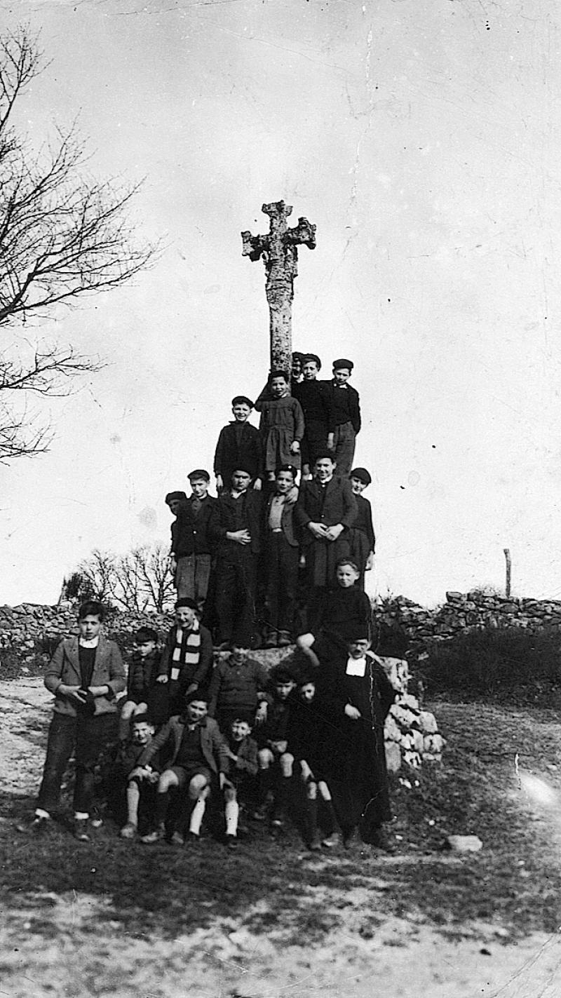 Ecoliers (escolans) et curé (curat) à la croix (crotz) de Saint-Juéry d'Autun, 1945