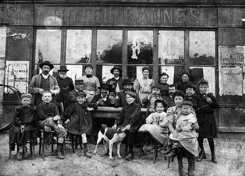 Personnes et enfants attablés devant l'hôtel Bannes, 1910