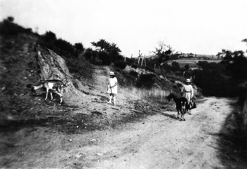 Deux jeunes filles gardant deux chèvres (cabras) au bord d'un chemin, en Viadène (secteur de Saint-Amans des Cots)
