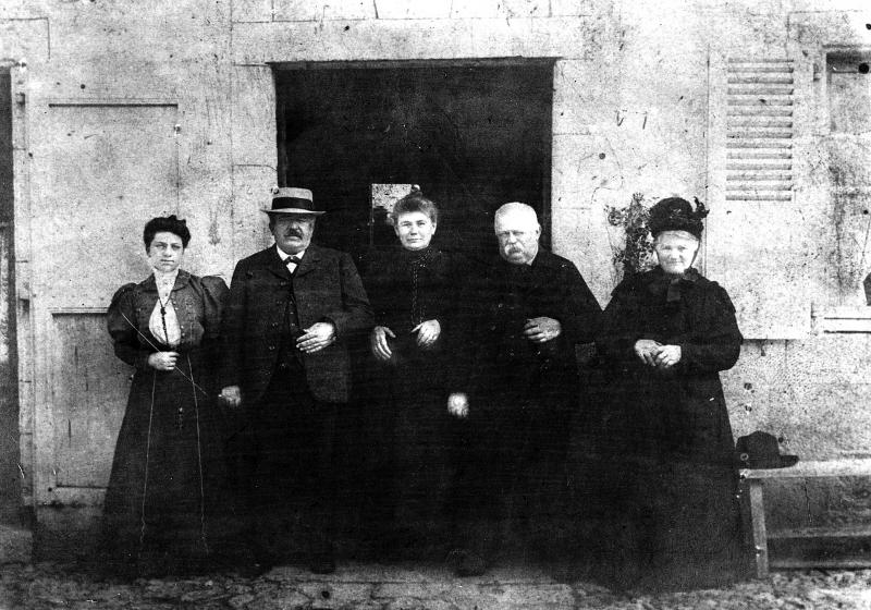 Famille Delfau devant porte d'entrée de maison (ostal)