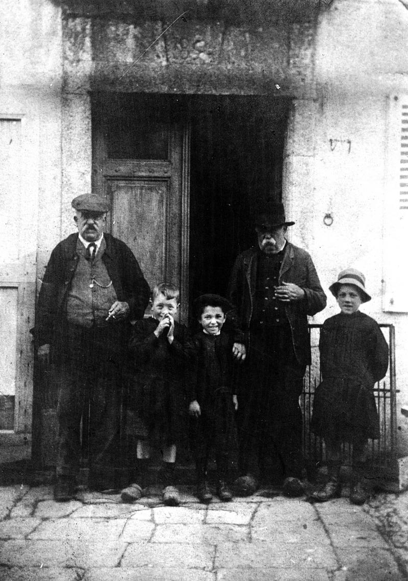 Famille Delfau devant porte d'entrée de maison (ostal)