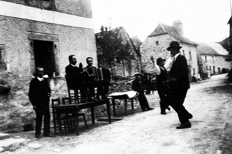 Duo masculin accordéon (acordeon) cabrette (cabreta) et danseurs (dançaires) de bourrée (borrèia) devant le café Chaliès, 1934