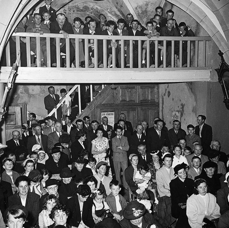 Paroissiens (parroquians) rassemblés dans l'église (glèisa) pour le baptême (batejalhas) d'une cloche (campana), 1953