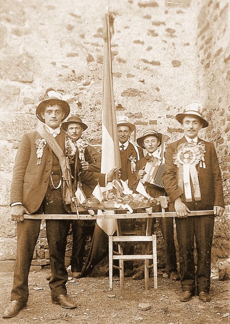 Conscrits, accordéoniste (acordeonista) et joueur de cabrette (cabretaire) montrant une fouace (fogassa), 1930