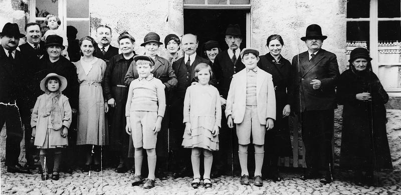 ​Famille devant porte d'entrée de maison (ostal), en Viadène (secteur de Sainte-Geneviève sur Argence)