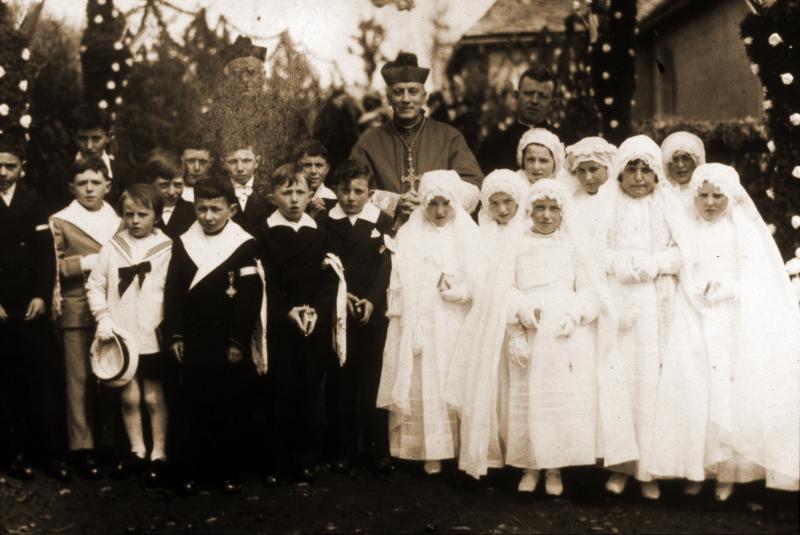 Communiants, communiantes en aubes, curé (curat) et évêque (evesque), à Douzalbats, 1939