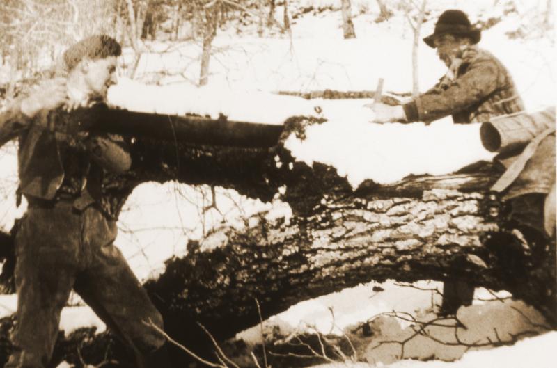 Deux hommes sciant un tronc d'arbre dans la neige (nèu), en Barrez