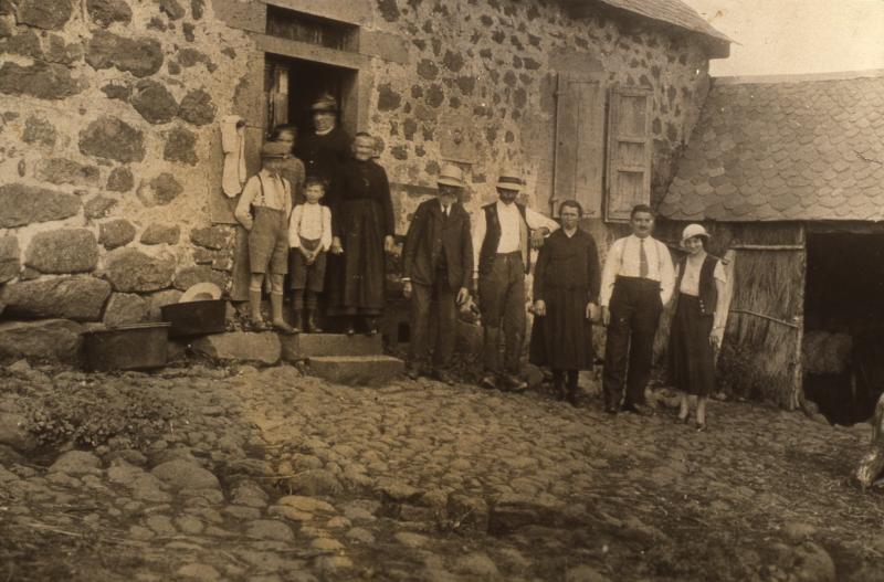 Famille devant porte d'entrée de maison (ostal) et hangar, en Barrez (secteur de Mur de Barrez)