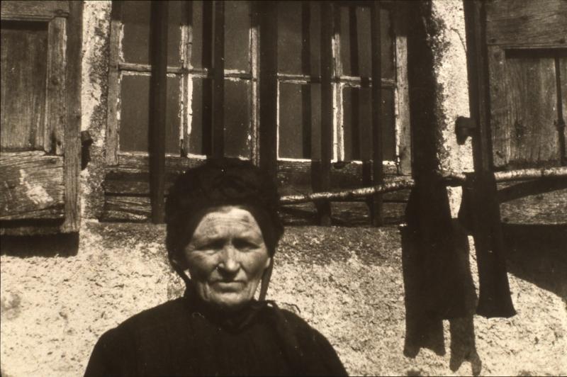 Vieille dame avec coiffe (còfa) devant fenêtre de maison (ostal), à Bonan, vers 1941
