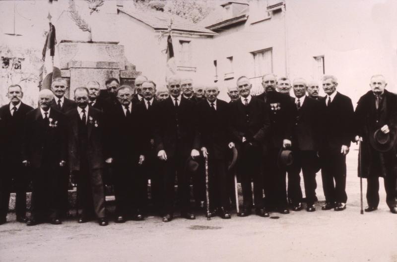 Anciens combattants de la guerre 1914-1918 devant le monument aux morts (monument als mòrts) pavoisé, 11 novembre 1968