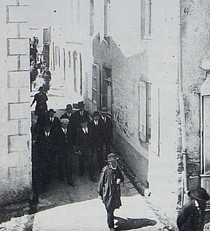  Paroissiens (parroquians) sortant de la messe dans une ruelle (carrièiron), 1920