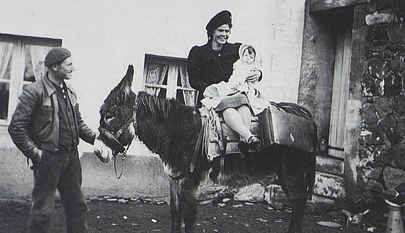 Homme, femme avec nourrisson juchés sur un âne (ase), à La Bastide d'Aubrac, 1942