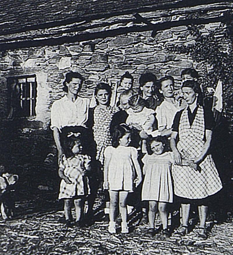Famille devant maison avec cheneaux en bois (canals), à Régaussou