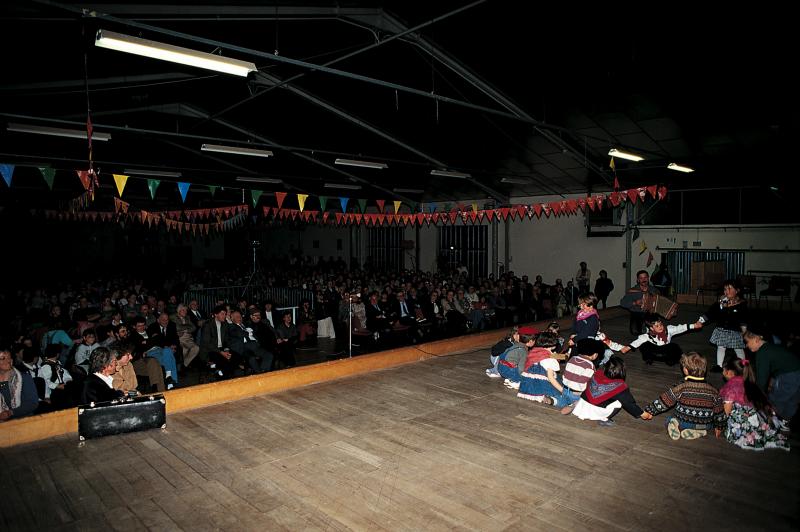Public et écoliers (escolans) avec accordéoniste (acordeonista) se produisant sur scène et à la soirée de clôture (velhada) de l'opération Al canton, à Bozouls, vendredi 22 avril 1994
