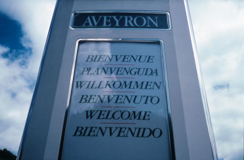  Panneau souhaitant la bienvenue en cinq langues placé à chaque entrée du département, secteur de Conques, juin 1994