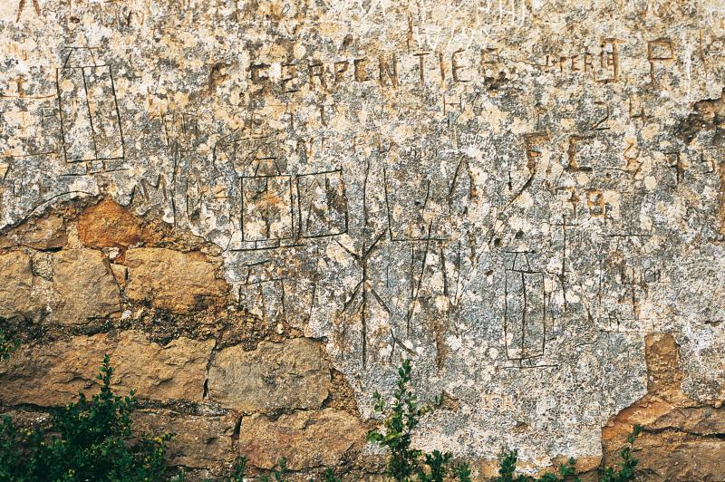 Inscriptions et représentation de scies (rèssas) de scieurs de long (ressaires de lòng) sur l'enduit extérieur de la chapelle du Saint-Sépulcre, février 1993