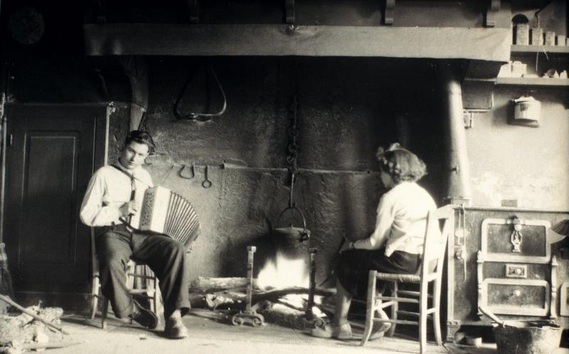 ​Accordéoniste (acordeonista) et femme se chauffant au coin du feu (canton), à Laubarède de Loupiac, 1950
