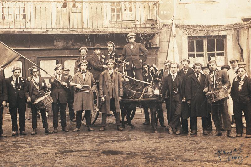 Conscrits de Laissac et Palmas, joueurs de tambour (tamborinaires), de clairon (claron) ou trompette (trompetaires) et âne (ase) attelé à un char (carri), 1924