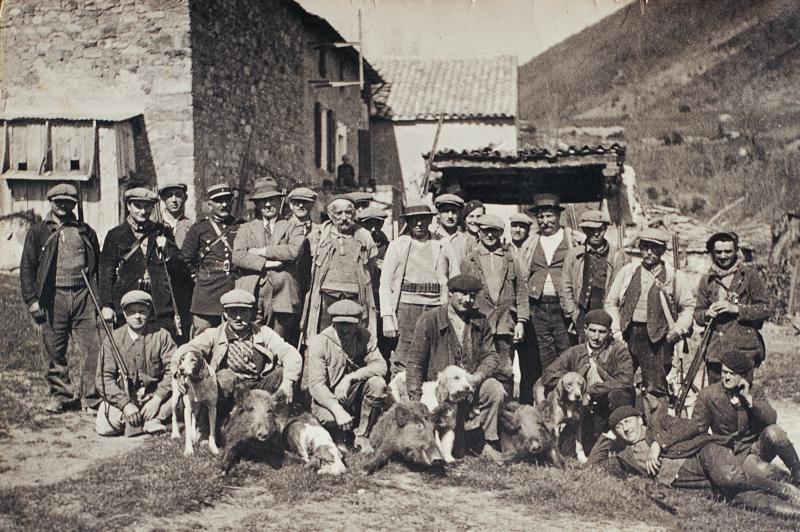 Chasseurs (caçaires) et chiens (cans) autour de trois sangliers (pòrcs singlars, singlars) abattus, 1934