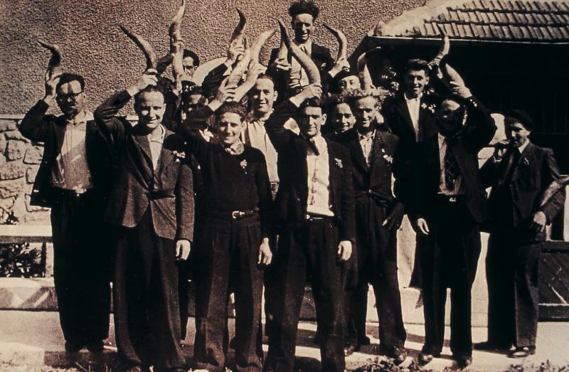 Jeunes hommes avec cornes (còrnas, banas) au-dessus de leur tête à la fête des mariés de l'année (cornards), 1946