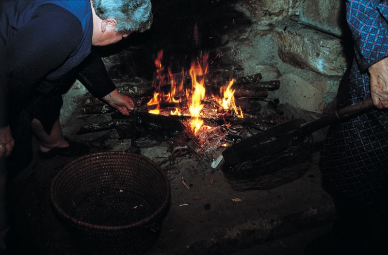 Deux femmes préparant le feu (fuòc) pour faire une grillée (grelada) de châtaignes (castanhas), à Castanet (82)