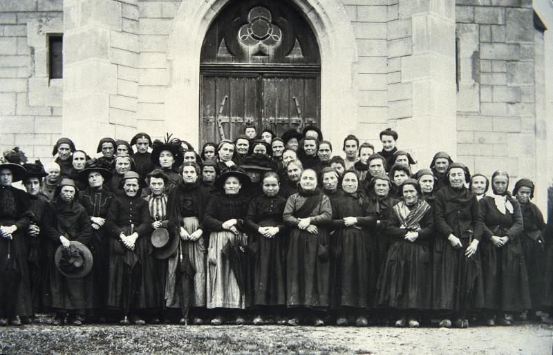 Paroissiennes (parroquianas) et paroissien (parroquian) devant la porte de l'église (glèisa), à Calcomier, 1912