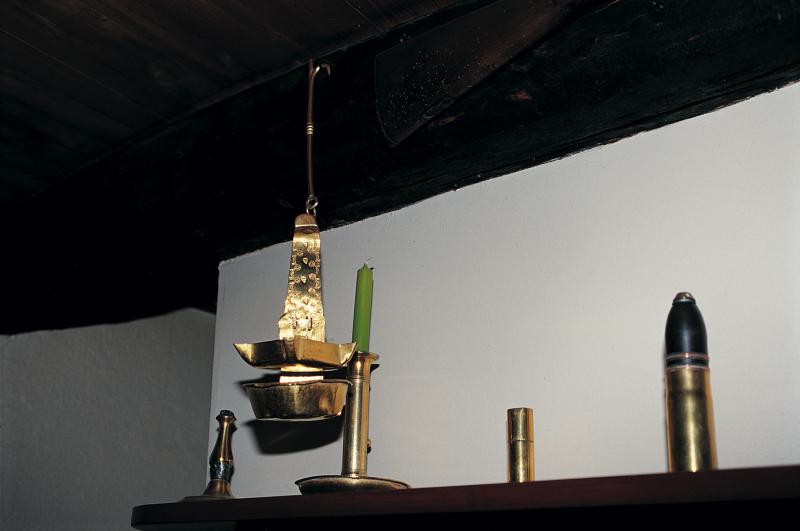 Lampe à huile (calelh) suspendue à une poutre (fusta) et objets en cuivre sur tablette (fusadièr) de cheminée (canton), dans le Villefranchois (secteur de Villefranche de Rouergue), avril 2002