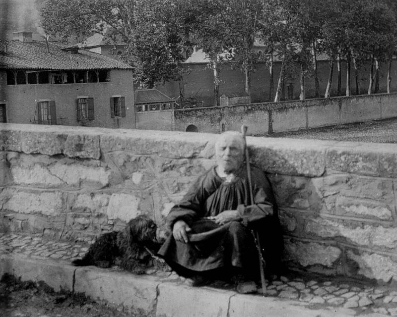 Mendiant (paure) avec son chien (can) faisant l'aumône sur un pont, dans le Villefranchois (secteur de Villefranche de Rouergue)