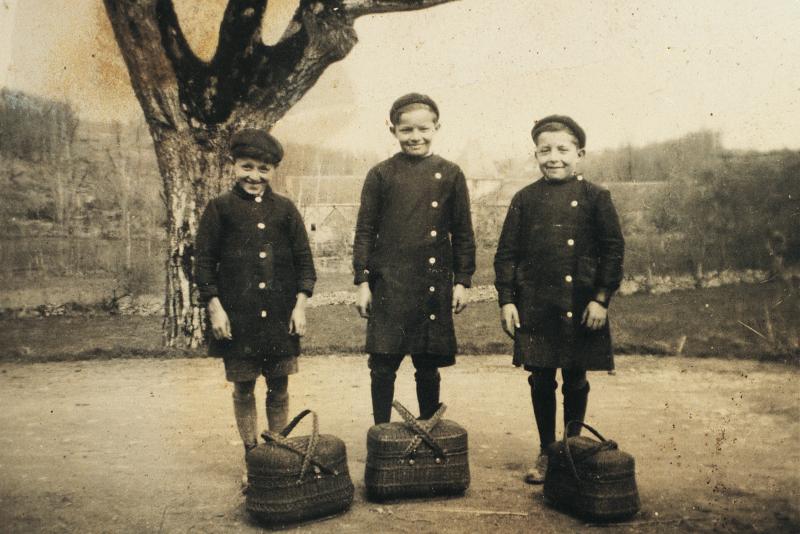 Temps de pause durant la quête (quista) des œufs (uòus) pour Pâques (Pascas), trois garçons avec paniers (panièrs) à couvercle noirs, à La Font, 1942 
