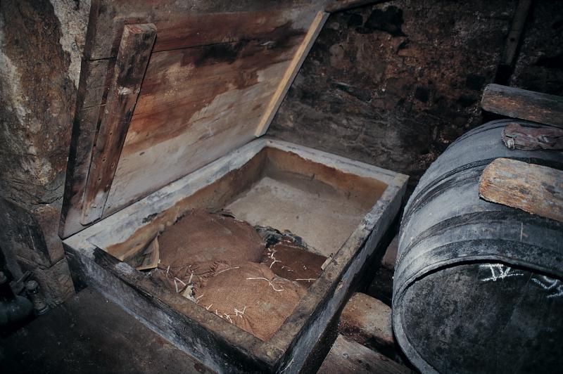 Deux jambons (cambajons) et une épaule (espatla) de cochon (pòrc, tesson) conservés dans des cendres (cendras) de bois dans une maie (mag), février 1995