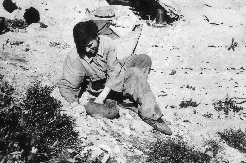 Homme effectuant des fouilles archéologiques à la grotte (bauma) des Cotes, 12 octobre 1952