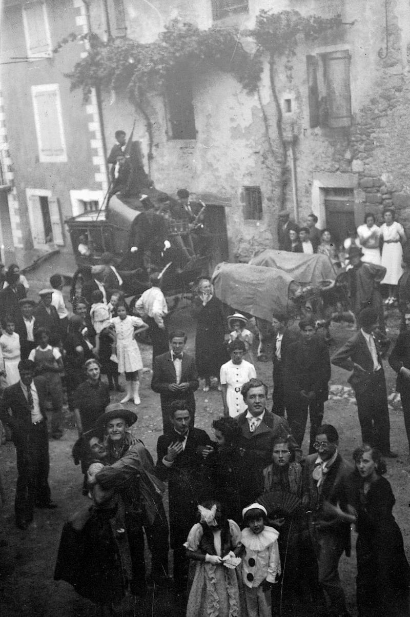 ​Villageois (vilatjors) costumés et paire de bovidés (parelh) attelée à une diligence (diligéncia) transportant un joueur de saxophone un jour de fête (fèsta, vòta), 1939