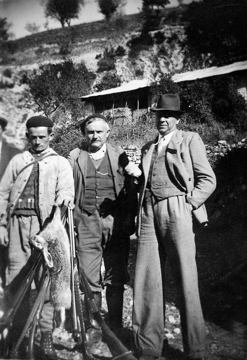 ​Chasseur (caçaire) présentant un lièvre (lèbre) et deux hommes, à Truans, 1940