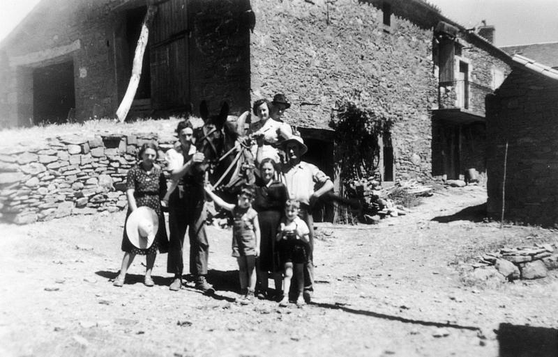  Personnes, dont deux juchées sur une mule (muòla), dans une cour de ferme (bòria), à La Garriette, 1952