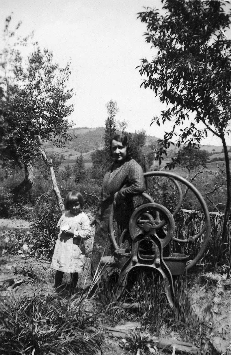 ​Jeune fille et femme à côté d'une pompe à eau à chapelets, au Moulin de Solayrol du Viala