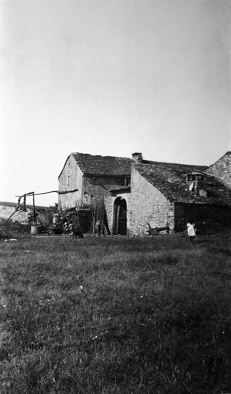  Chenaux en bois, puits (potz) ou citerne (cistèrna), enfants devant portail (portal) d'entrée de cour de ferme (bòria), aux Fournials, 1935-1940