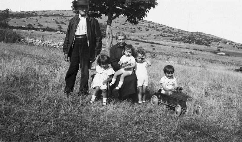  Grands-parents (rèire-grands) avec quatre petits-enfants (pichons-enfants) dans une prairie (prada, prat), aux Fournials, 1935-1940