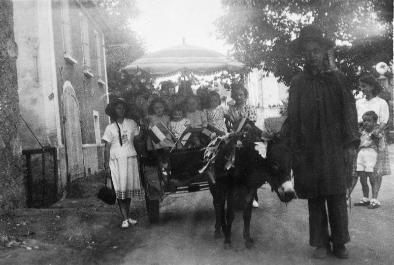 Jeune homme conduisant un âne (ase) attelé à un char (carri) transportant des enfants pour la kermesse paroissiale, 1948