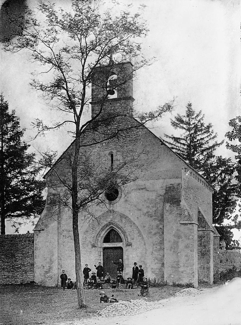 Enfant devant la chapelle (capèla) Notre-Dame de la Joie avec son clocheton, au cimetière (cementèri)