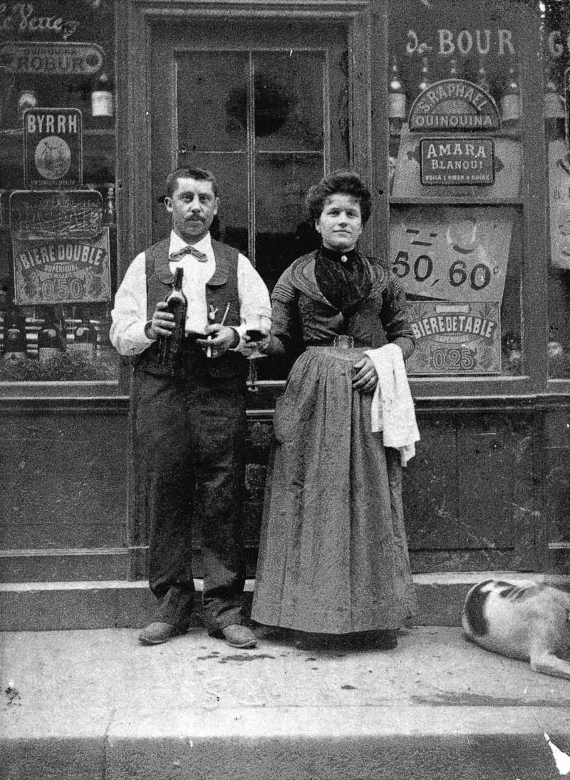  Homme et femme sur le pas de porte d'un débit de boissons, à Paris (75), vers 1907