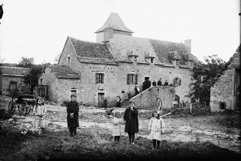 Enfants (dròlles, enfants) dans la cour, famille sur le perron (pompidor) d'une maison (ostal), aux Bouysses, 1916