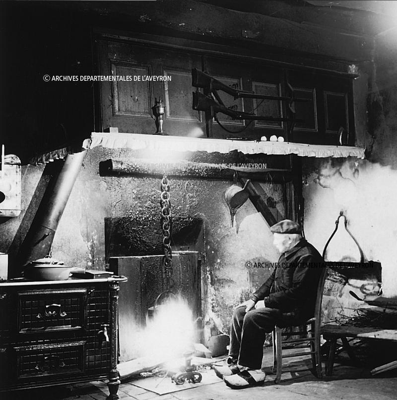 Cuisinière (cosinèira) en fonte, homme se chauffant au coin du feu (canton), 2 novembre 1975