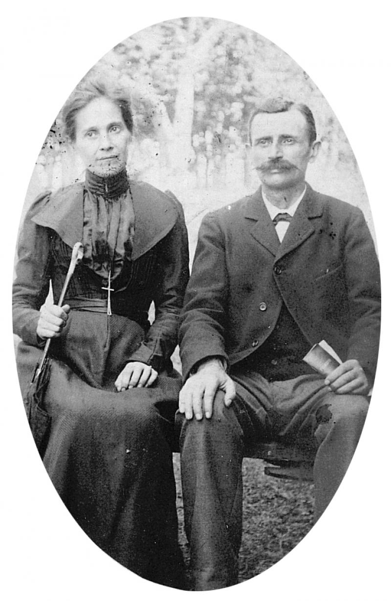 Femme avec ombrelle et homme, maire de La Salvetat, avec livret dans la main assis