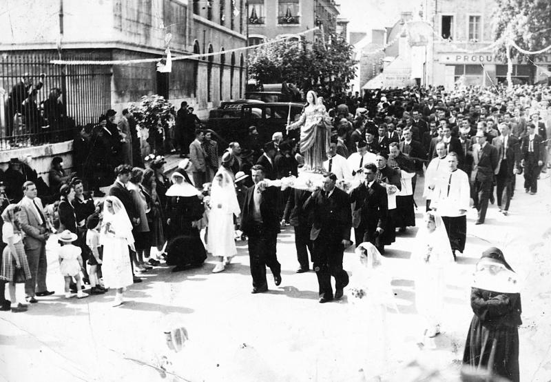 Passage de la procession des paroissiens (parroquians) de Notre-Dame Roucayrol devant la préfecture, à Rodez, juin 1951
