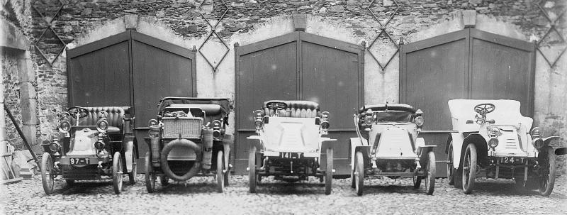 Cinq automobiles devant trois portes de garages, au château (castèl) du Bosc